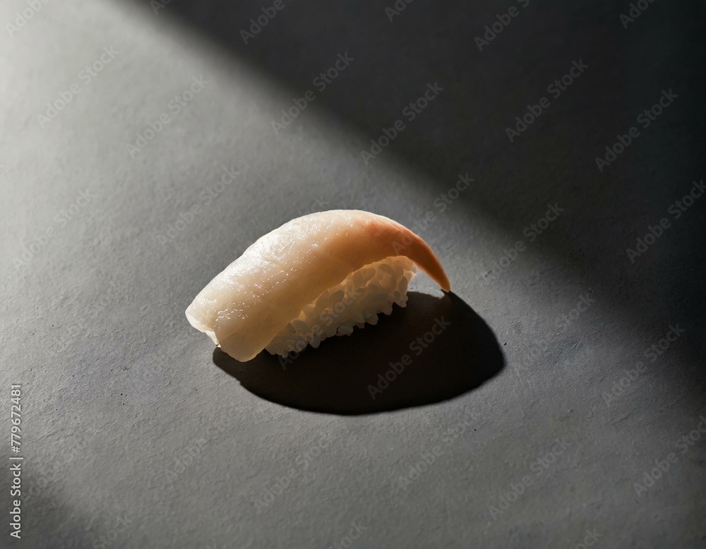 A single sushi piece, perfectly formed, rests on a smooth black slate surface, highlighting the contrast and the art of simplicity A single sushi piece, perfectly formed, rests on a smooth black slate surface, highlighting the contrast and the art of simplicity