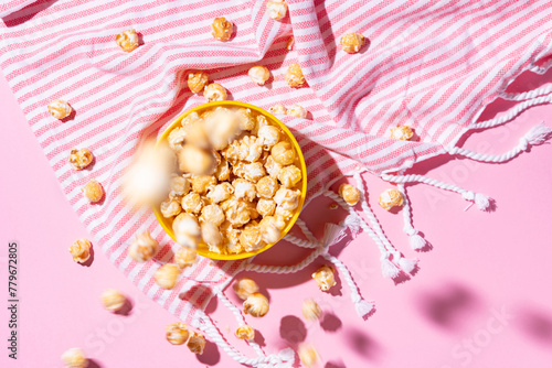 Caramelized popcorn dropping down into a yellow bowl
