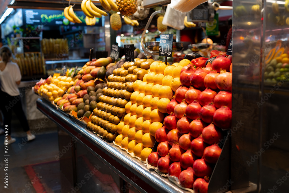 Fresh fruits on shelf in market. Healthy concept. Heap of fresh red pomegranates, kiwi, orange