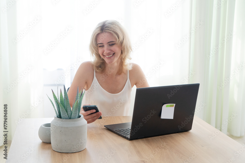 Happy 40s woman working with modern laptop at her home, distant work concept Happy 40s woman working with modern laptop at her home, distant work concept