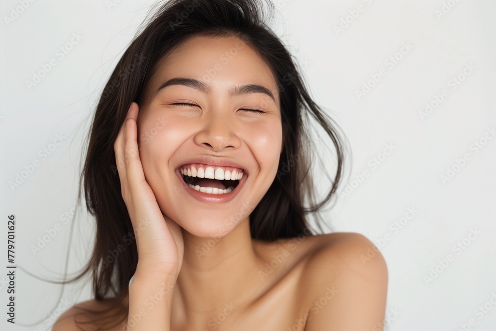 woman laughing with her hands, her head tilted back and eyes closed in joy. She has short hair styled. The background is neutral with soft lighting, highlighting her expression and skin texture. woman laughing with her hands, her head tilted back and eyes closed in joy. She has short hair styled. The background is neutral with soft lighting, highlighting her expression and skin texture.