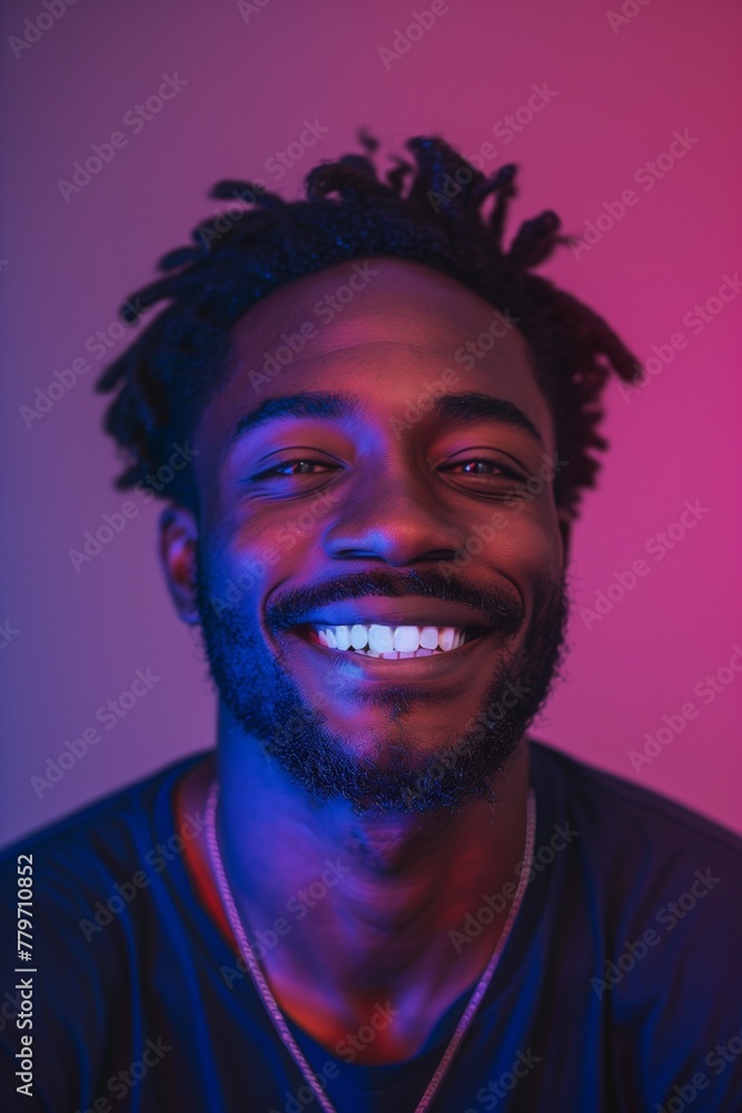 Portrait of a young smiling African American man in neon light. Portrait of a young smiling African American man in neon light.
