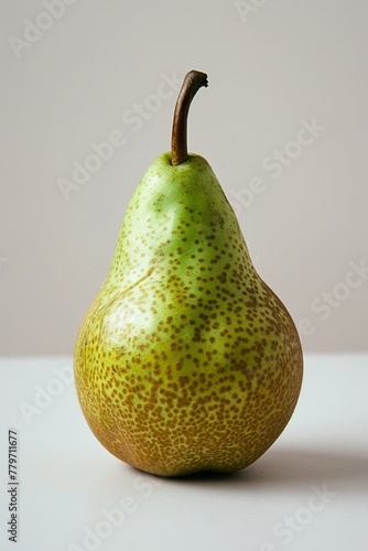 A single, ripe pear, green and fresh, against a white backdrop