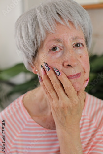 Senior woman with artsy multicolored long nails