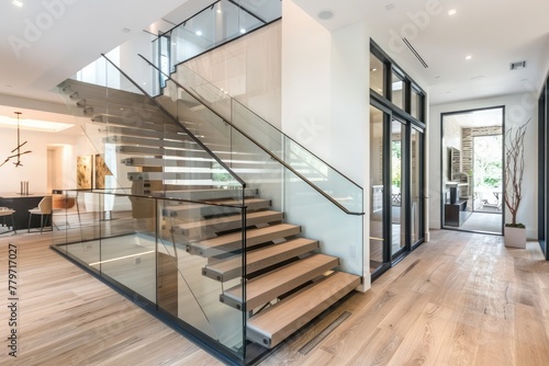 A contemporary interior design element featuring glass fencing and wooden stairs