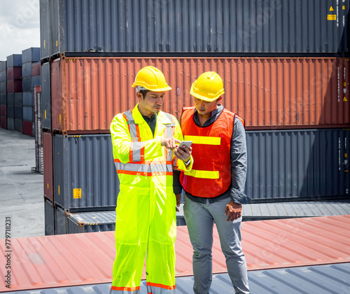 Group of professional dock worker and engineering people wearing hardhat safety helmet and safety vest standing and Looking at the machine, lifting the container trainer into the storage area.
