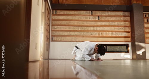 Japanese student, bow or man in dojo to start aikido practice, discipline or self defense education. Black belt master greeting, athlete learning respect or ready in fighting class or training alone photo