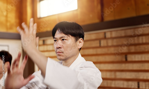 Japanese student, aikido or training martial arts in dojo for practice, fighting education or self defense. Combat routine, wellness or male person with workout, body movement and class with peace