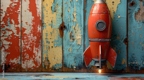 A red rocket toy takes off into the sky on a colorful wooden background. Leaving a trail of excitement and wonder in its wake.