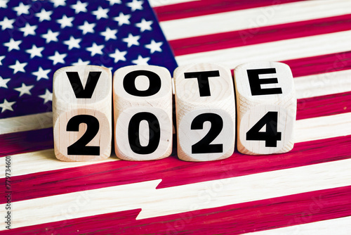 Wooden cubes with text VOTE 2024, lying on the USA flag as backdrop.United States presidential election in 2024
