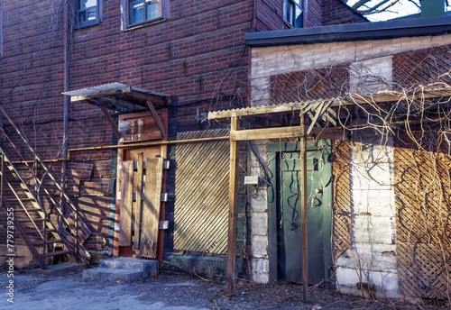 Abandoned house with wooden door and fence in the city.