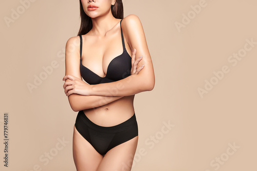 Confident beautiful young asian woman posing in black lingerie on beige background, Perfect body,