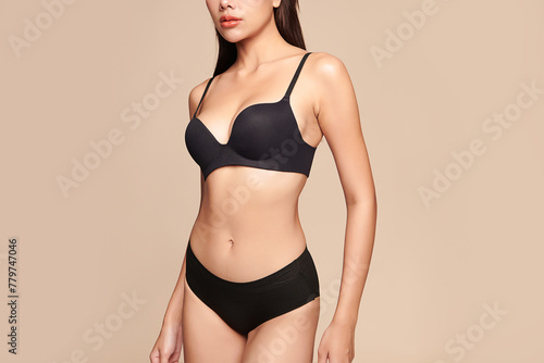 Confident beautiful young asian woman posing in black lingerie on beige background, Perfect body,