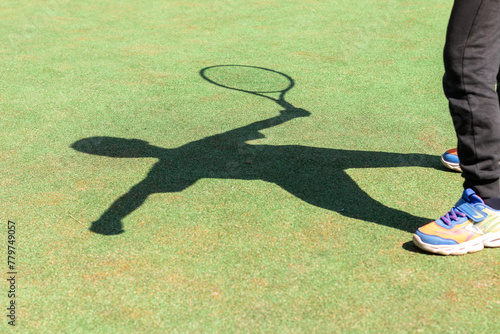 Shadow of a boy playing tennis on the tennis court © Mikhail