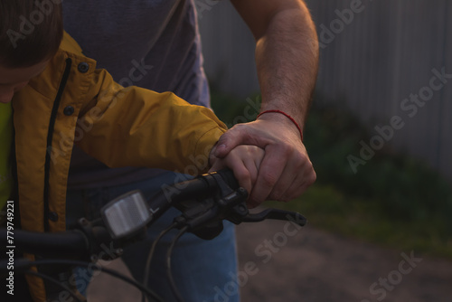 Father teaching his son to ride a bicycle. Close-up image