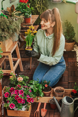 Happy Woman Gardener Kneeling at City Balcony