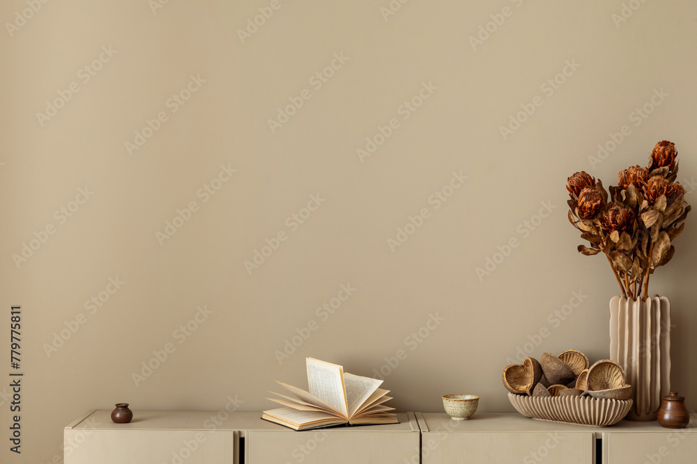 Minimalist composition of living room interior with copy space, simple beige sideboard, vase with dried flowers, books and personal accessories. Home decor. Template. - obrazy, fototapety, plakaty 