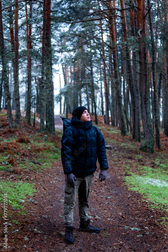 Portrait of a Latino man with mountain gear, embracing snowy Guadarrama scenery.