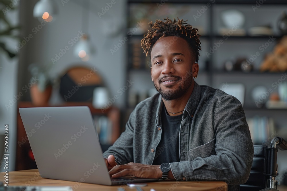 Fototapeta premium Portrait of a smiling successful businessman working on laptop at his office, looking at camera.