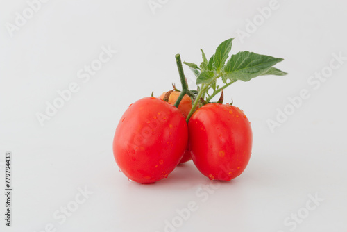 Red ripe tomatoes wilh leaf on a white background
