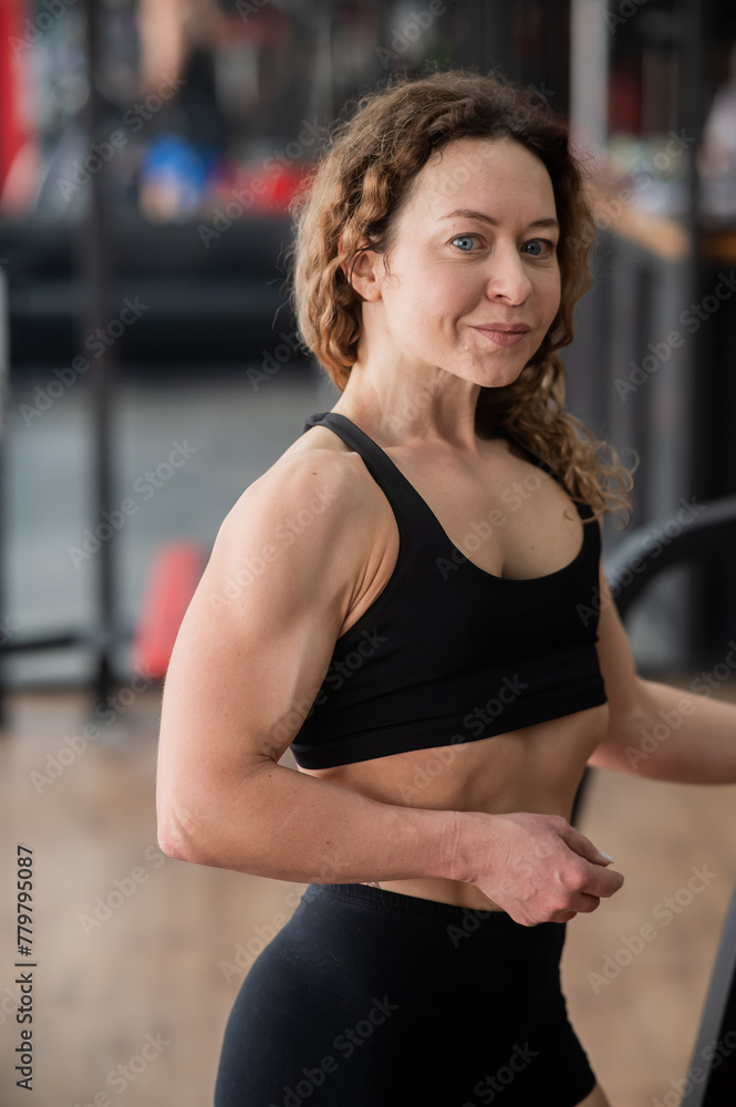 Middle aged woman posing in the gym. 