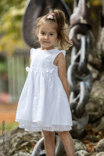 Cute little girl in white dress, posing and smiling