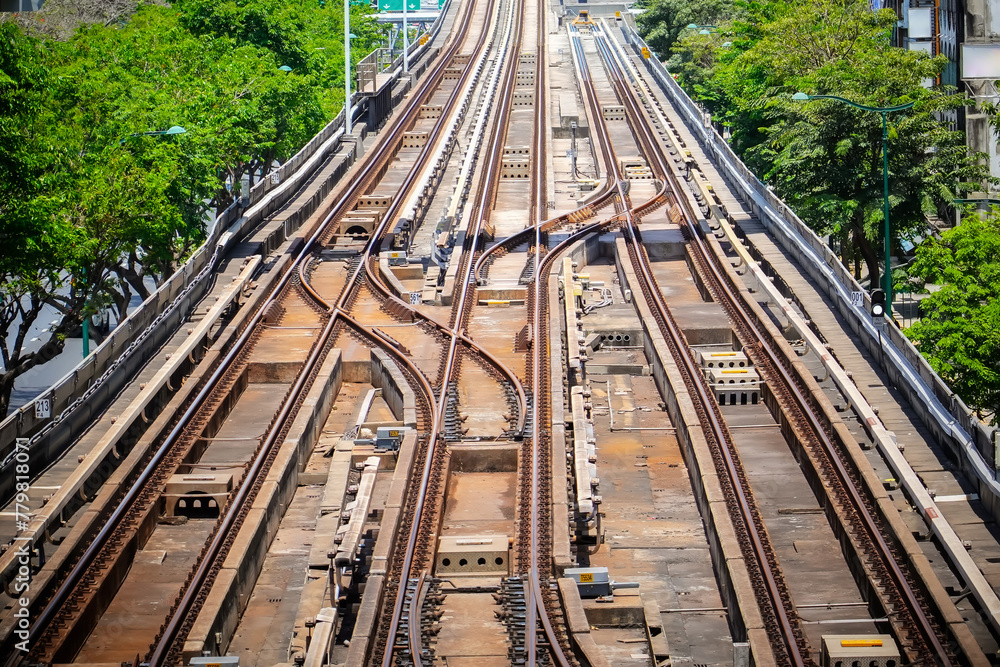 Obraz premium Top aerial view of the railway tracks and railway switches at the distribution station next to the train depot. Looking into the distance perspective