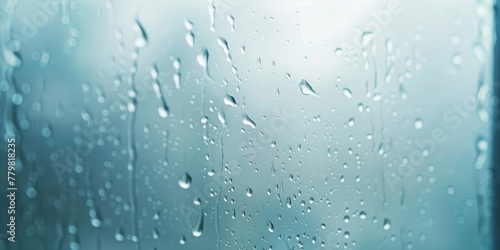 A window with raindrops on it. The raindrops are scattered all over the window  creating a blurry and hazy effect. Scene is calm and peaceful  as the raindrops seem to be falling gently