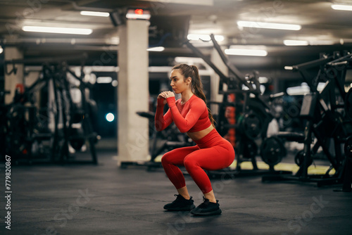 A female athlete is doing squats endurance at the gym.