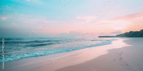 A beautiful beach with a pink and blue sky. The water is calm and the sand is white
