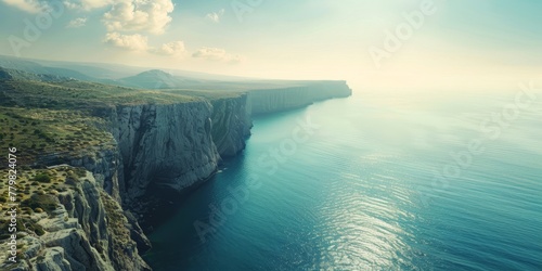 A beautiful ocean view with a cliff in the background. The water is calm and the sky is clear