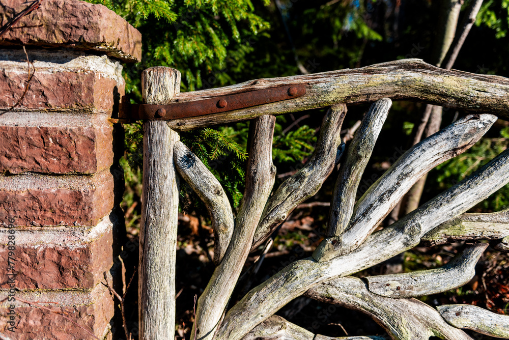 fragment of nice closed wooden garden gate. door made of tree branches fragment of nice closed wooden garden gate. door made of tree branches