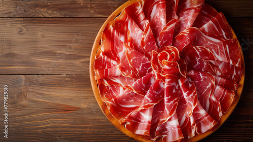 Thin slices of jamon on a wooden board. View from above. Free space for text, copy space. Wooden background, table.
