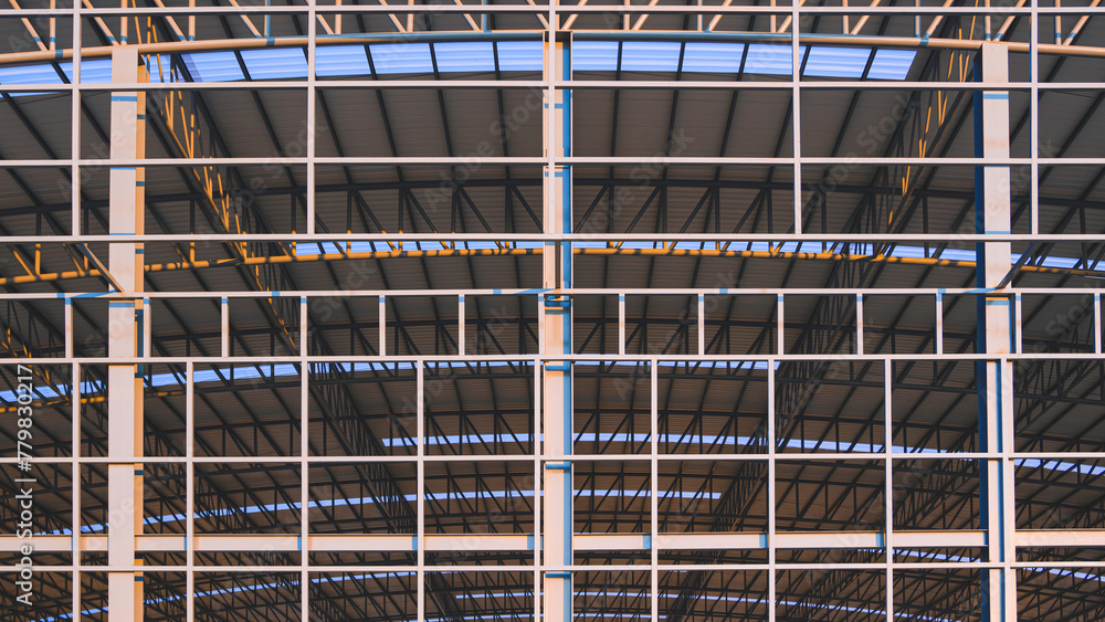 Large metal industrial factory building structure background with corrugated steel curve roof and skylights in construction site area, symmetric front view 