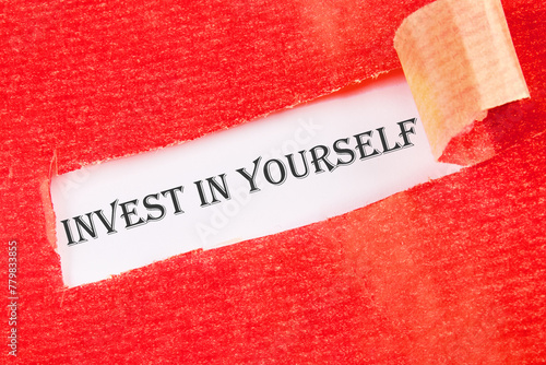 invest in yourself word on a white background under torn paper
