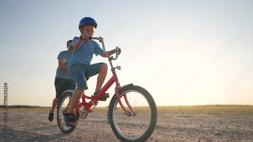 family play in the park. father teaching son to ride a bike. happy family kid dream concept. son learn to ride sunset a bike silhouette. father supporting child son riding bike summer in the park family play in the park. father teaching son to ride a bike. happy family kid dream concept. son learn to ride sunset a bike silhouette. father supporting child son riding bike summer in the park