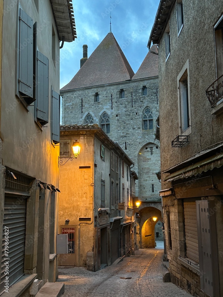 Street leading to the medieval gate in old town Carcassonne during the dawn, Occitania, France, February 2023