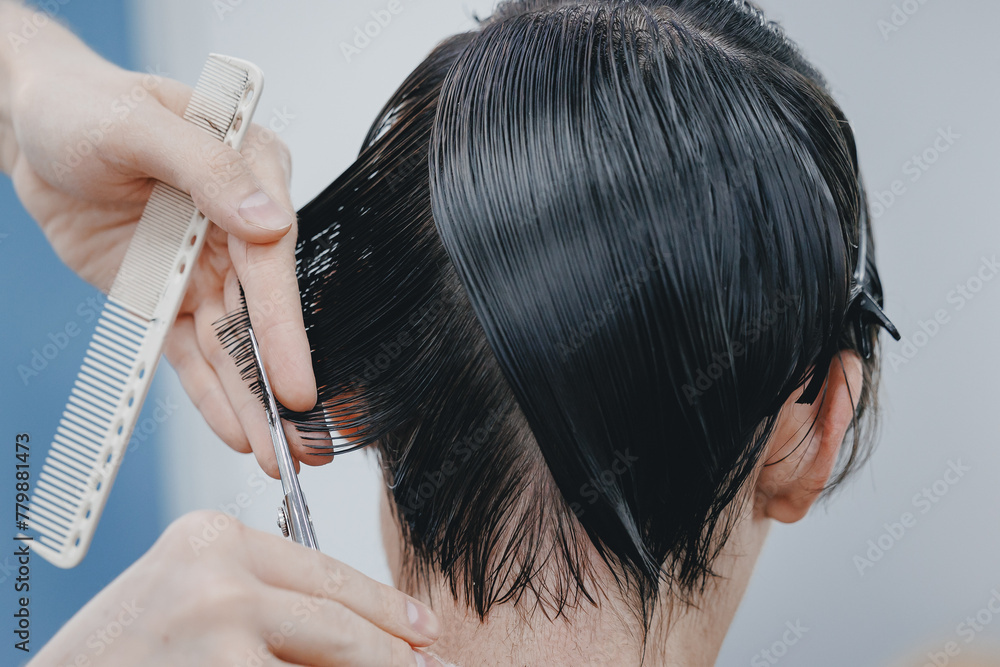 Naklejka premium Concept Barbershop for man. Closeup master hairdresser does hairstyle and style with scissors and comb