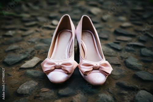 A pair of blush pink velvet flats with a dainty bow detail, on a soft velvet fabric. photo
