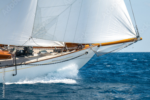 White Dacron sails on a classic wooden sail boat with wooden masts.