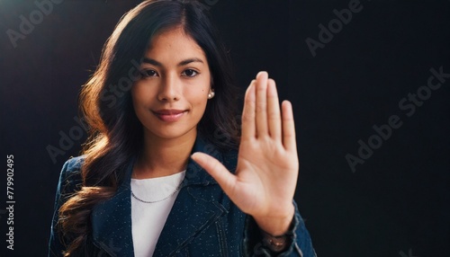 Close up of woman showing stop gesture with hand raising up on black background, young female protesting against domestic violence and abuse, bullying, saying no to gender discrimination 