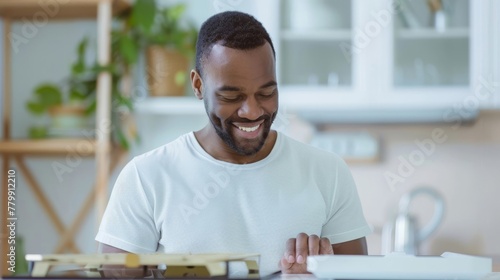 Smiling man enjoying assembling a model airplane at home