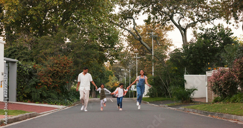 Foto Family, parents and kids in street, skipping and playful with love, care or holding hands in neighborhood