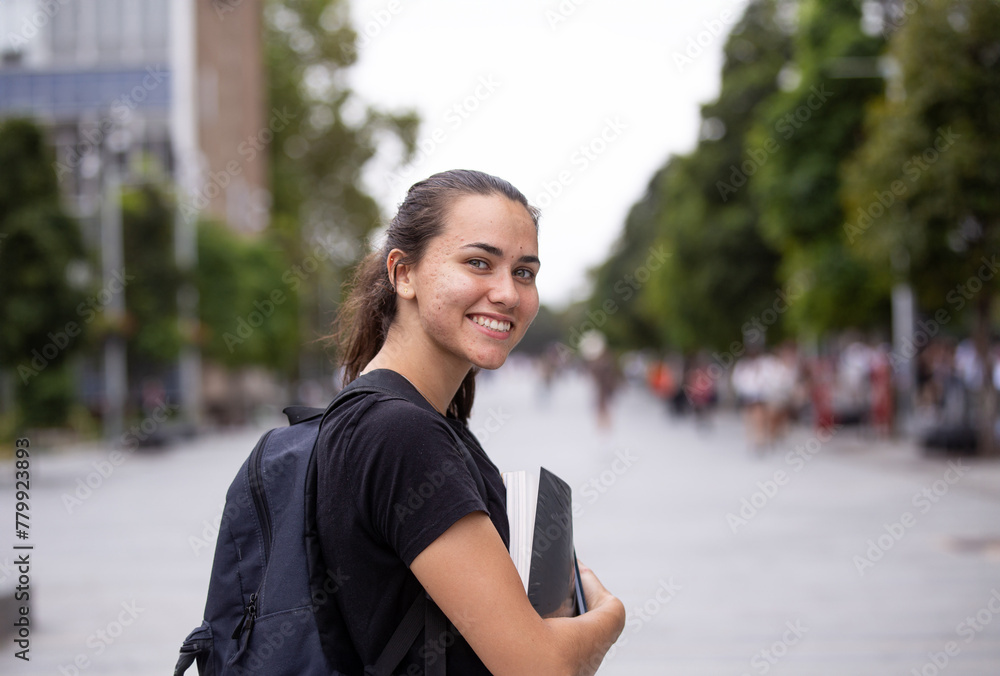 Happy aboriginal female university student holding textbooks Happy aboriginal female university student holding textbooks