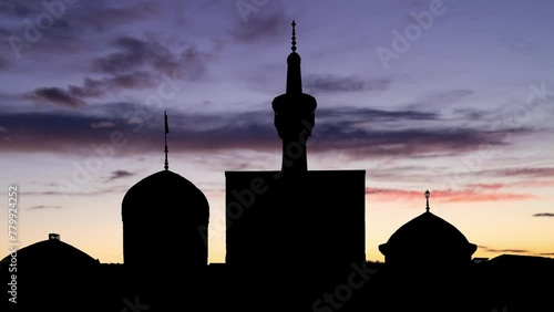 Mosque of Imam Reza in Mashhad, Iran,. Time Lapse at Twilight with Colourful Sky and Dark Silhouette of Mnaret and Dome photo
