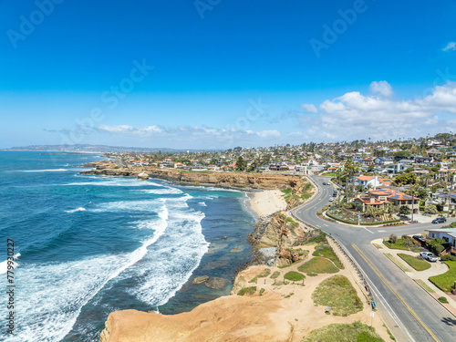 Aerial panorama of Sunset Beach in San Diego with ragged California ocean coastline, crushing waves, luxury single family homes and residences with pools photo