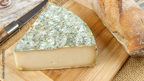 fromage français : Saint-Nectaire fermier, en gros plan, sur une planche à découper	
 photo
