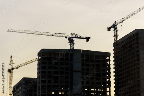 Construction cranes on top of a building under construction. The cranes are engaged in the construction work of the building. © Алексей Филатов