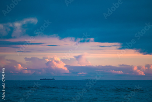 Cargo ships lined up at sea on their way to Newcastle Harbour under a vibrant sunset sky photo