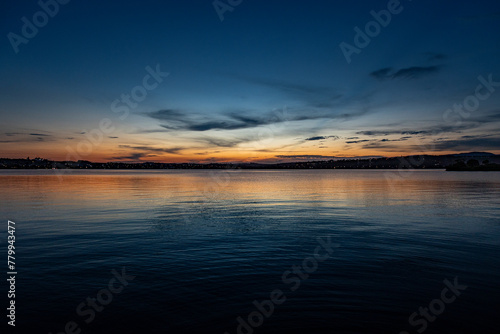 cores do céu do pôr do sol, refletindo na textura da agua da lagoa photo